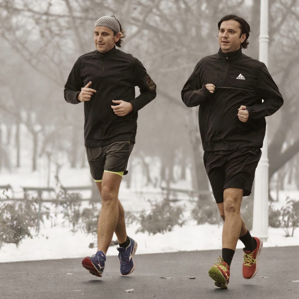 Two male friends running