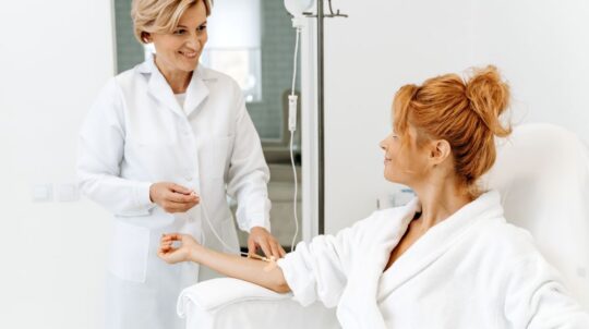 A woman speaking to a clinician about the benefits of IV therapy.