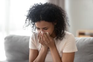 Sick woman blowing nose and struggling with immune system.