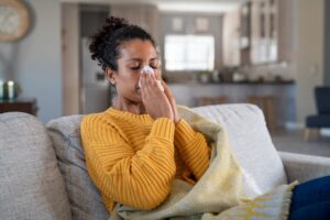 woman sneezing before a cold